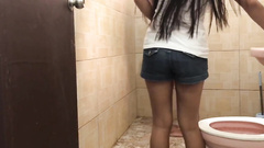 Asian babe sneakily blows him in a public restroom
